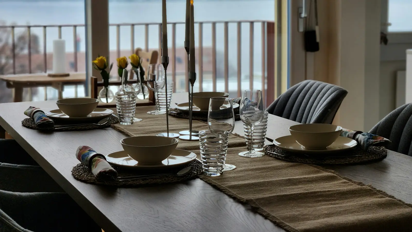 Mesa de comedor puesta junto a un ventanal con vistas